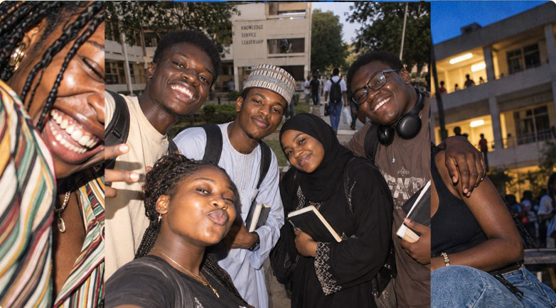 Three students laughing together on campus in the evening